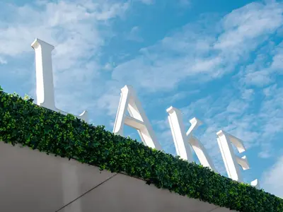 a white sign with green ivy on the side of a building at Amsterdam Lake Hotel in Badhoevedorp