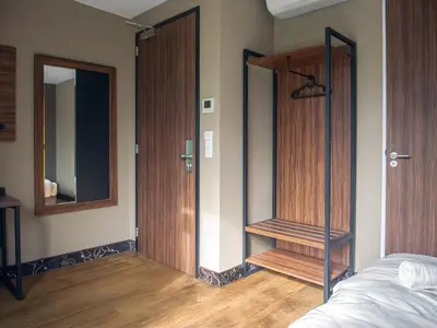 a room with two wooden doors and a mirror at Amsterdam Lake Hotel in Badhoevedorp