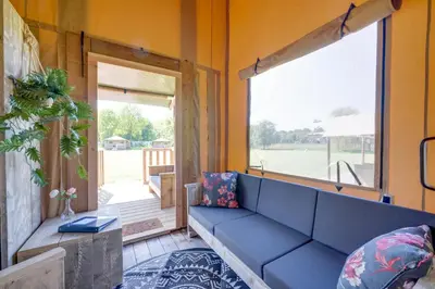 a living room with a blue couch and a window at Sunny Trio in Zeewolde