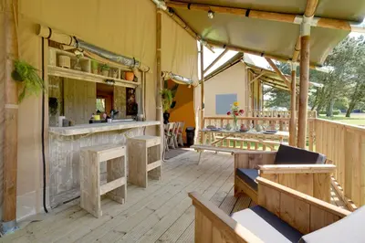 a restaurant patio with benches and a bar at Sunny Trio in Zeewolde