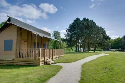 a small building with a porch and a gravel path at Sunny Trio in Zeewolde