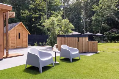 a yard with two chairs and a table in the grass at Sunny Trio in Zeewolde