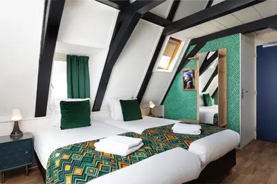 two beds in a room with green walls at Boutique Hotel des Arts in Amsterdam