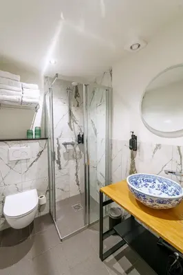 a bathroom with a sink and a toilet and a shower at Boutique Hotel des Arts in Amsterdam