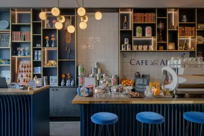 a restaurant with a counter with blue stools at Boutique Hotel des Arts in Amsterdam