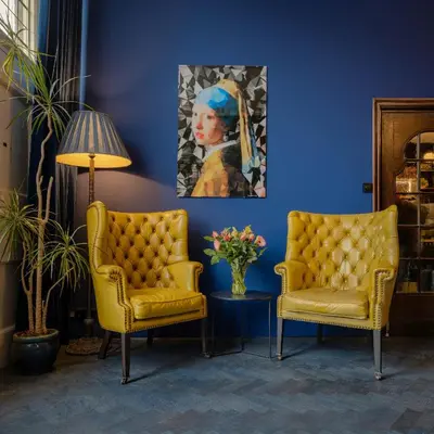 a room with two chairs and a painting of a woman at Boutique Hotel des Arts in Amsterdam