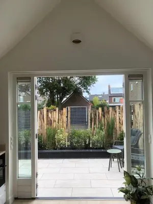 an open door to a patio with a fence at Dune Vieuw in Zandvoort