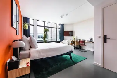 a bedroom with a bed and a table and a desk at Gooiland Hotel in Hilversum
