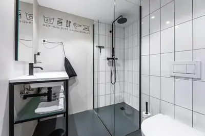 a bathroom with a shower and a sink and a toilet at Gooiland Hotel in Hilversum