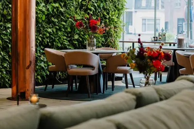 a restaurant with a table and chairs and flowers at Gooiland Hotel in Hilversum