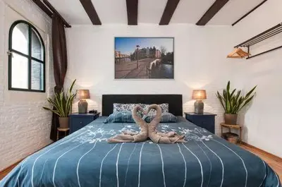 two people laying on a bed in a bedroom at Crown Guesthouse Amsterdam in Amsterdam