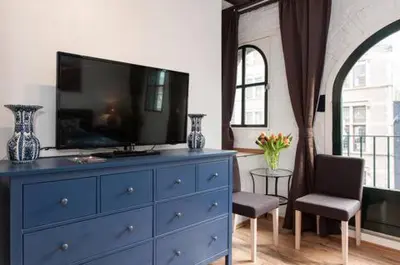 a blue dresser with a television on top of it at Crown Guesthouse Amsterdam in Amsterdam