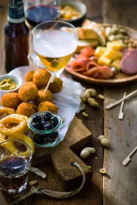 a table with a plate of food and a glass of beer at Campanile Hotel & Restaurant Gouda in Gouda