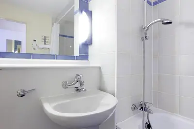 a white bathroom with a sink and a shower at Campanile Hotel & Restaurant Gouda in Gouda
