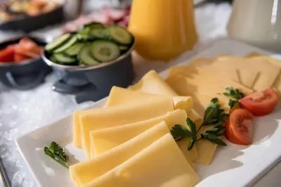a plate of cheese and vegetables on a table at Campanile Hotel & Restaurant Gouda in Gouda