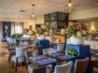a dining room with tables and chairs and flowers at Campanile Hotel & Restaurant Gouda in Gouda