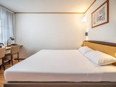 a hotel room with a bed and a desk at Campanile Hotel & Restaurant Gouda in Gouda