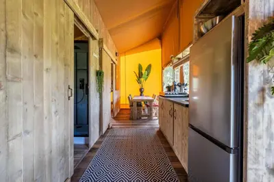 a kitchen with yellow walls and a stainless steel refrigerator at Sunny Lodge 6 persoons in Zeewolde