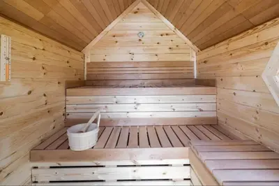 a wooden sauna with a bucket in it at Sunny Lodge 6 persoons in Zeewolde