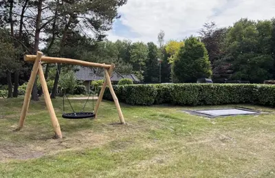 a swing set in a yard with at Sunny Lodge 6 persoons in Zeewolde