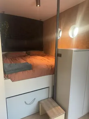 a small bedroom with a bed and a closet at Cozy Cabin at houseboat in Amsterdam