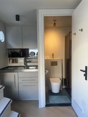a kitchen with white cabinets and a sink at Cozy Cabin at houseboat in Amsterdam