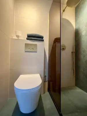 a bathroom with a white toilet and a shower at Cozy Cabin at houseboat in Amsterdam