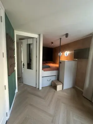 a room with a bedroom with a bed in it at Cozy Cabin at houseboat in Amsterdam