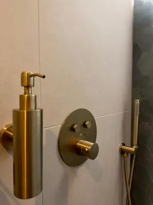 a brass toilet paper dispenser with a face on the wall at Cozy Cabin at houseboat in Amsterdam