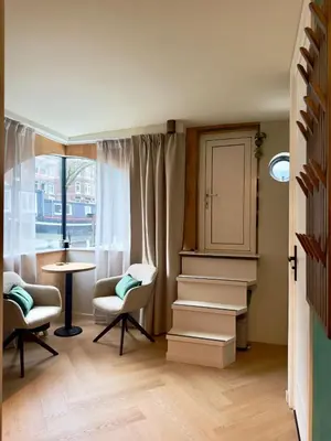a room with two chairs and a table and a window at Cozy Cabin at houseboat in Amsterdam