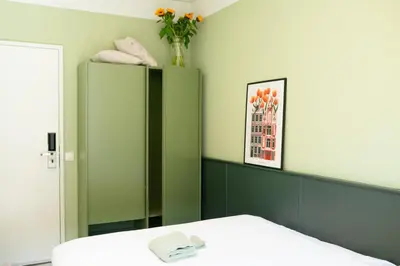 a room with a green cabinet and a bed at Hotel La Bohème in Amsterdam
