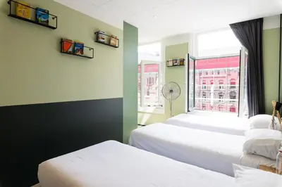 a bedroom with two beds and a window at Hotel La Bohème in Amsterdam