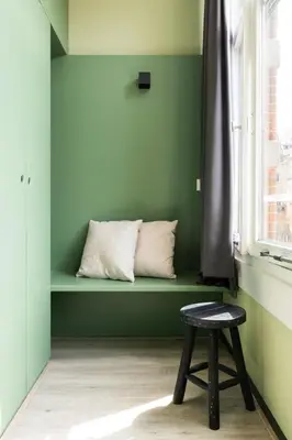 a bench with a stool in a room with a window at Hotel La Bohème in Amsterdam