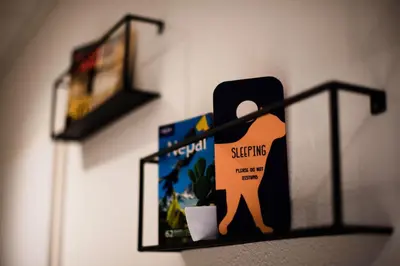 a shelf with a picture of a person holding a book at Hotel La Bohème in Amsterdam