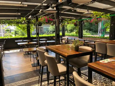 a restaurant with wooden tables and chairs and plants at Boutique Hotel Chariot - Amsterdam Schiphol Airport in Aalsmeer