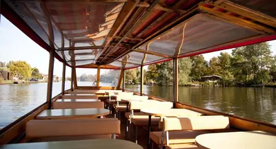 a boat with tables and chairs on the water at Boutique Hotel Chariot - Amsterdam Schiphol Airport in Aalsmeer