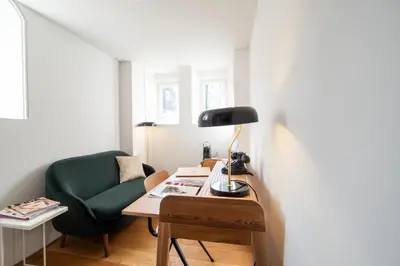 a desk with a lamp and a green chair at Hotel Arena in Amsterdam