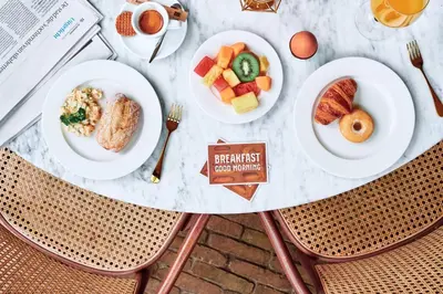 a table with plates of breakfast food on it at Hotel Arena in Amsterdam