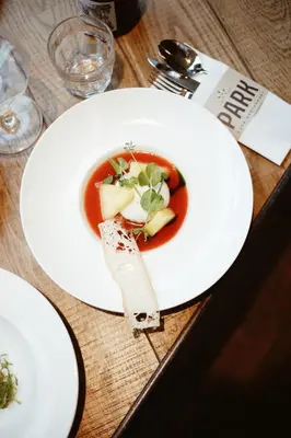 a white plate with a bowl of soup on a table at Hotel Arena in Amsterdam