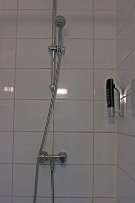 a shower with a shower head and a hair dryer at Koopermoolen in Amsterdam