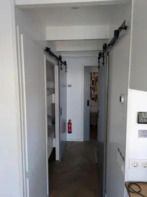 a hallway leading into a room with white walls and wood floors at Surla Houseboat 