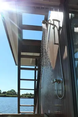 a shower in a building with a ladder at Surla Houseboat 