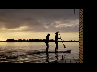two people standing on a paddle board in the water at Surla Houseboat 