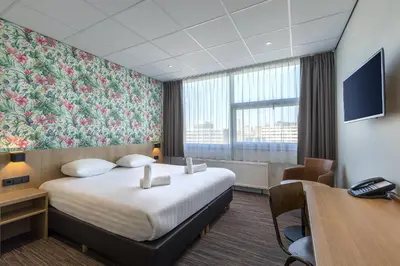 a hotel room with a large bed and a desk at Best Western Amsterdam in Amsterdam