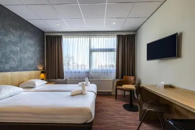 a hotel room with two beds and a flat screen tv at Best Western Amsterdam in Amsterdam