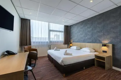 a hotel room with a bed and a desk at Best Western Amsterdam in Amsterdam
