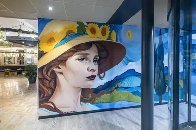 a mural of a woman with a hat on a wall at Best Western Amsterdam in Amsterdam