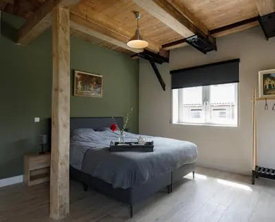 a bedroom with a large bed and a large window at De Dinkelhoeve in Heemstede