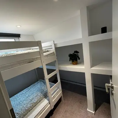 a bunk bed room with two bunk beds and a plant at Ferienvilla 10 Minuten vom Strand in Dirkshorn