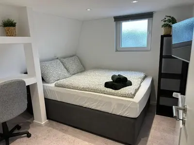 a bedroom with a bed with a black teddy bear on it at Ferienvilla 10 Minuten vom Strand in Dirkshorn